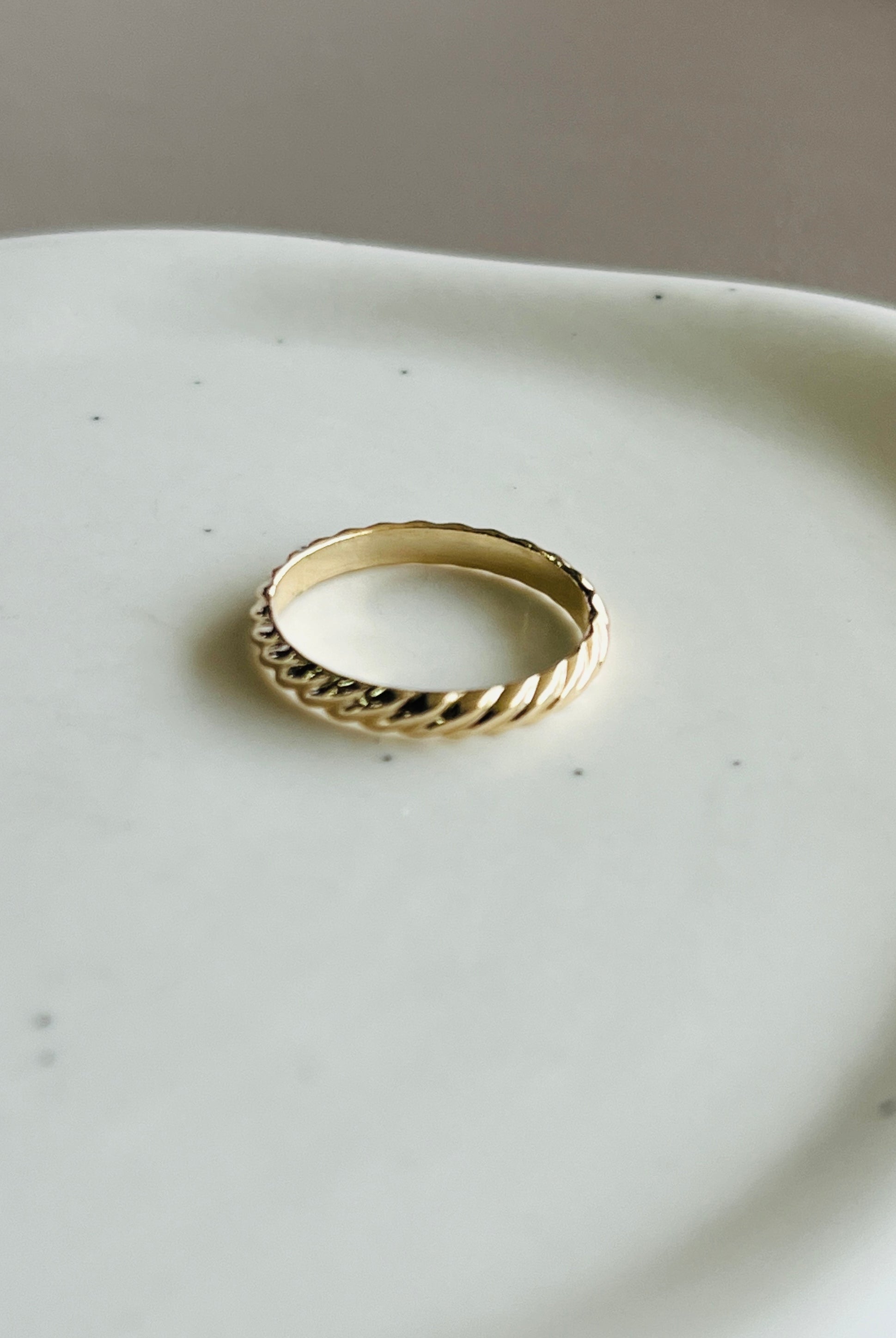 a gold ring sitting on top of a white plate