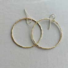 Load image into Gallery viewer, a pair of gold hoop earrings on a white surface
