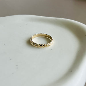 a gold ring sitting on top of a white plate